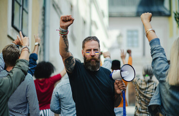 Wall Mural - Crowd of activists protesting against Russian military invasion in Ukraine walking in street.