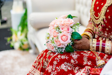 Canvas Print - Indian bride's holding wedding flowers hands close up