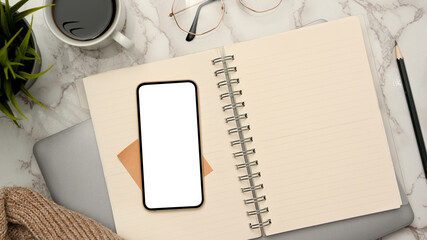 Wall Mural - Feminine office desk with empty page on spiral notepad, smartphone mockup