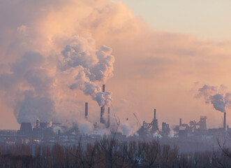 Wall Mural - Smoke from the chimneys of a steel plant at sunset