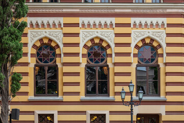 Wall Mural - Fragment of a wall of a building with picturesque windows decorated with stucco