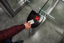 Close Up Of Unrecognizable Swiping Card Passing Turnstile To Enter Building. The Hand Holds The Card. Access Denied.