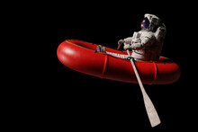 Astronaut In Red Dinghy, Isolated On Black Background