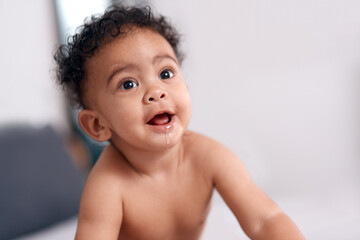 Babies make a home a lot more happier. Shot of an adorable baby boy on the bed at home.