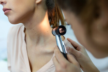 Doctor dermatologist examines skin of patient. Dermatoscopy, prevention of melanoma, skin cancer.