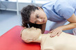 © Graphicroyalty - woman practicing cpr technique on dummy during first aid training. First Aid Training - Cardiopulmonary resuscitation. First aid course on cpr dummy.