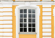 Classical window with white frame in yellow stone wall