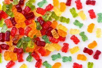 Wall Mural - Small gummy bears are scattered on a white background