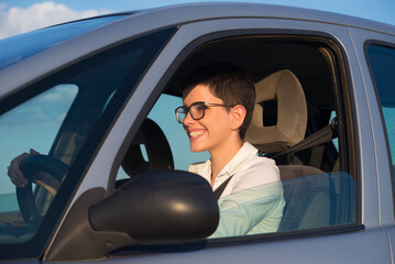 Young beautiful woman driving car on a sunny day.