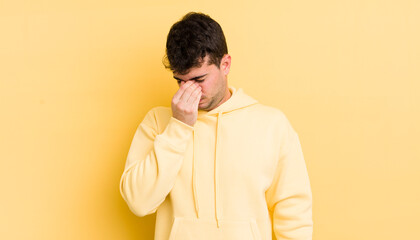 Wall Mural - young handsome man feeling stressed, unhappy and frustrated, touching forehead and suffering migraine of severe headache