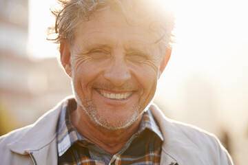 Hes got a sunny outlook on life. Portrait of a friendly-looking middle aged man outside.