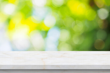 Marble table top with blur green leaf bokeh nature background