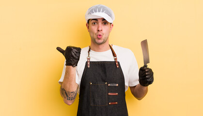 Wall Mural - young handsome man looking astonished in disbelief. butcher concept