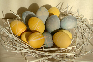 Easter eggs with a beautiful eco-friendly pattern lying in a decorative nest of white rods