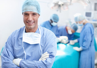 Wall Mural - I have a team of surgical experts behind me. Portrait of a happy, confident and professional doctor with his team of surgical experts behind him.