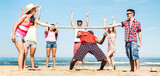 Fototapeta  - Multicultural friends group having fun together with limbo game at beach vacation - Summer joy life style concept with young multi ethnic people playing on spring break vacation - Bright filter