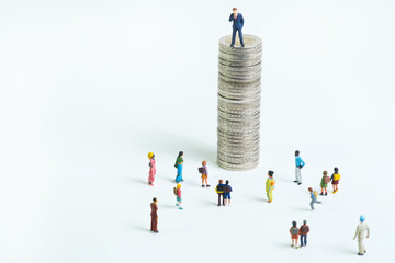 Canvas Print - a successful businessman looks down at a crowd from a tall coin tower