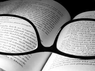 Sticker - Closeup of an open book with eyeglasses on it