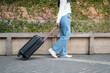 Asian woman tourist is going to holiday trip and walking to dragging with black luggage to passengers lounge