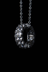 Poster - Vertical shot of a ring hanging from the steel chain on the black background