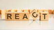 react text on a wooden blocks, gray background.