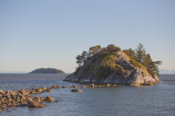 Canvas Print - Beautiful view of a sea and a small island with mountains in the background