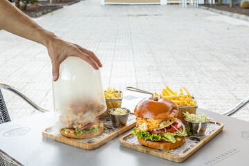 Wall Mural - Delicious hamburger with French fries on a wooden board