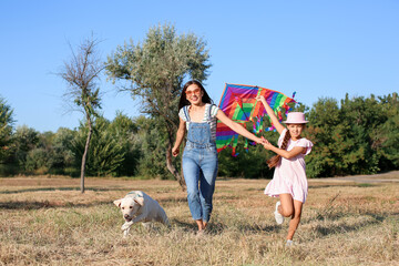 Poster - Cute little girl with her mother and dog flying kite in park