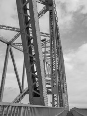 Sticker - Black-and-white vertical shot of a metal bridge in a gloomy weather