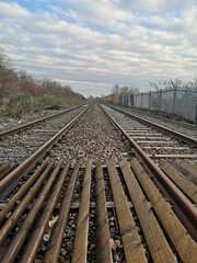 Poster - Vertical shot of an empty railway tracks under a cloudy sky