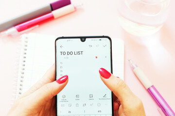 Canvas Print - Woman using a mobile phone to list her task