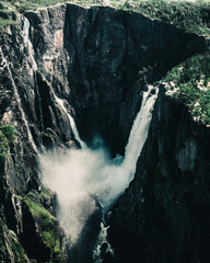 Sticker - Vertical shot of a waterfall rapidly flowing down from the high cliff