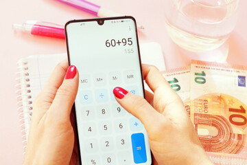 Canvas Print - Closeup shot of a female doing calculations on the phone