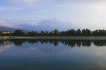 Wall Mural - long exposure of a lake reflecting trees and a mountain