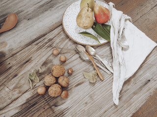 Sticker - Top view of pears in a plate several nuts and spoons on a wooden table