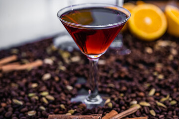 Wall Mural - Red cocktail in a martini glass on a bar with coffee beans