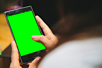 Canvas Print - Female holding a smartphone with a green screen for copy space