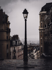 Canvas Print - Vertical shot of a lamppost against a gray cloudy sky