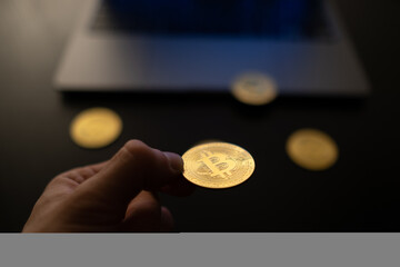 Poster - Closeup of the hand holding a bitcoin. Selected focus.