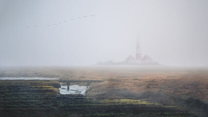 Wall Mural - Westerheversand Lighthouse in a moody fog in Westerhever, Germany