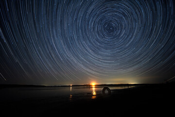 Wall Mural - Star trails above a lake