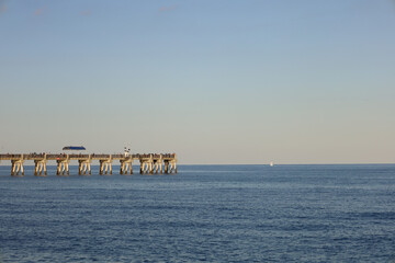 Sticker - Calm view of the relaxing blue water of the sea with a pier on a fine day