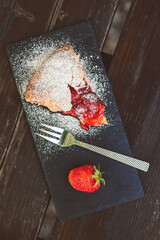 Canvas Print - Vertical closeup of the strawberry cake as dessert on a slate tray.