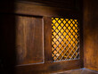 Closeup of a wooden window of the confessional box at church