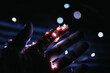 Closeup shot of a man holding the silver wire lights at night