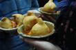 Close-up shot of a hand holding a plate with delicious samosa