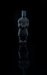 Sticker - Vertical shot of a terracotta stone figure isolated on a black background