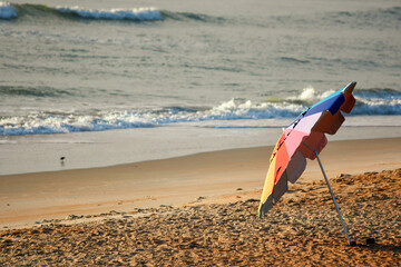 Sticker - Colorful beach umbrella on a sandy coast