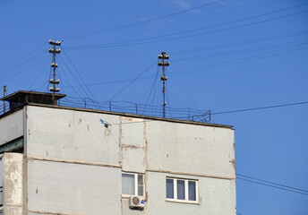 Wall Mural - View of an exterior house with two communication towers on the roof against a blue sky