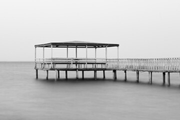 Sticker - Greyscale shot of a wooden pier over the sea